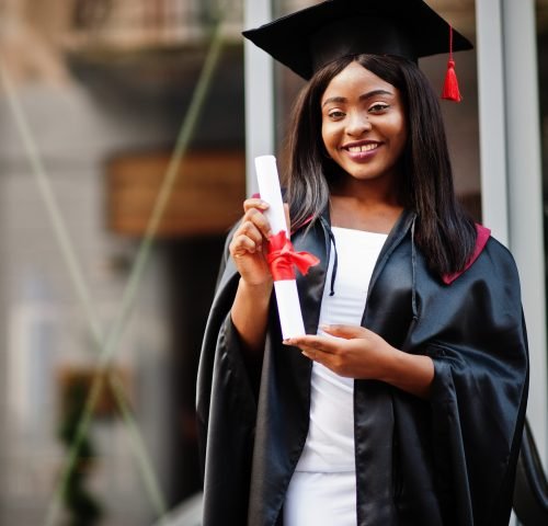 Young female african american student with diploma poses outdoor Young female african american student with diploma poses outdoors.